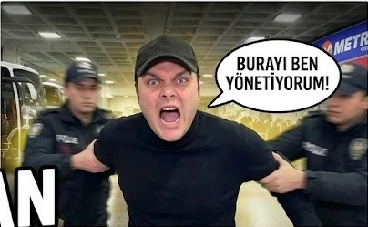 Otogarda iki polis arasında bağıran şapkalı adam, konuşma balonu: Burayı ben yönetiyorum!